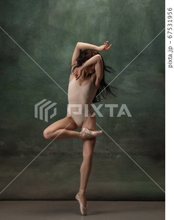 Young graceful tender ballerina on dark green studio background Young graceful tender ballerina on dark green studio background 67531956