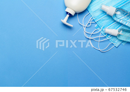 bottle of lotion, sanitizer or liquid soap and protective mask over blue background - flat layout bottle of lotion, sanitizer or liquid soap and protective mask over blue background - flat layout 67532746