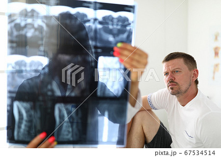 Man and doctor are examining xrays closeup Man and doctor are examining xrays closeup 67534514