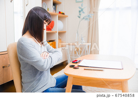 書類を確認する女性　様々な書類　腕を組む　 67540858