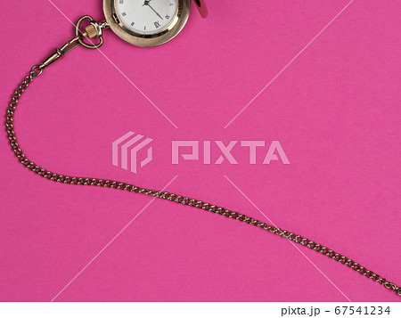 Watch on a chain on a pink background.の写真素材 [67541234] - PIXTA