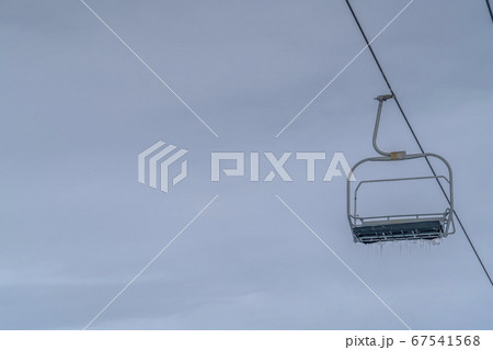 Empty chair lift with icicles against cloudy sky Empty chair lift with icicles against cloudy sky 67541568