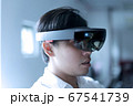 Asian business man wearing hololens glasses to experiment mixed reality. 67541739