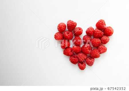 Fresh raspberries heart shaped composition isolated on white background with a copy space 67542352