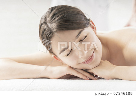 明るい雰囲気のエステサロンでマッサージを受ける若い女性 明るい雰囲気のエステサロンでマッサージを受ける若い女性 67546189