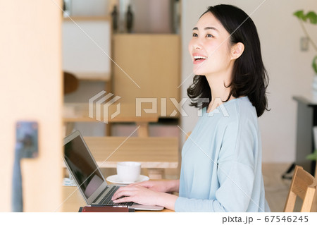 ノートパソコンにに向かう女性 カフェ の写真素材