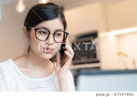 在宅ワーク ダイニングにてノートパソコンを前にしてスマホで電話する眼鏡を掛けた女性 在宅ワーク ダイニングにてノートパソコンを前にしてスマホで電話する眼鏡を掛けた女性 67547900