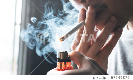A man is smoking a cigarette at home 67549876