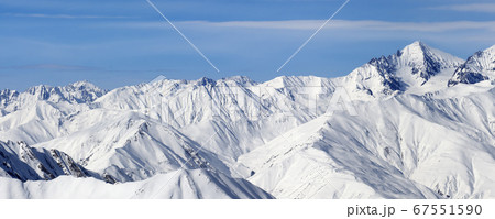 Panoramic view on high snowy mountains and blue 67551590