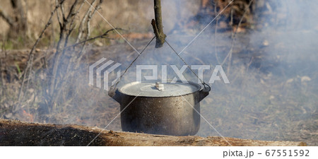 Cooking in sooty cauldron on campfire 67551592