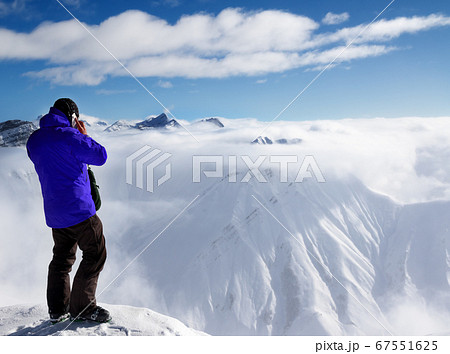 Skier at top of mount and snowy mountains in fog 67551625
