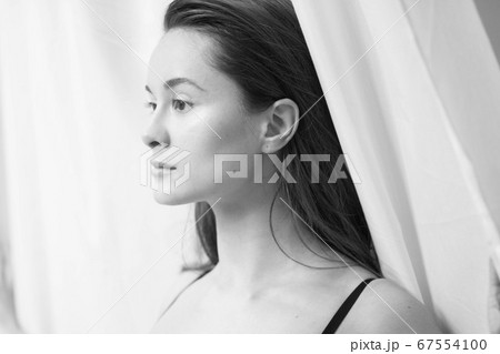 woman at window and curtain front happy face 67554100
