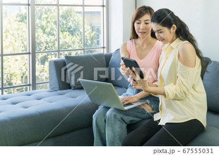 Adult Asian women are using technology together. Adult Asian women are using technology together. 67555031
