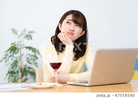 オンライン飲み会 疲れて眠くなる若い女性の写真素材