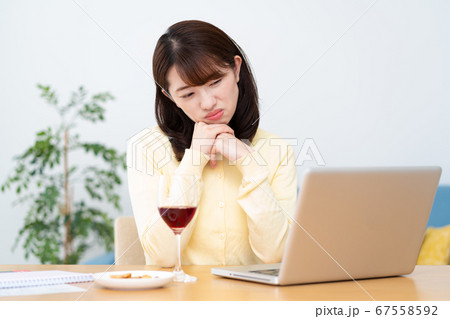 オンライン飲み会 疲れて眠くなる若い女性の写真素材