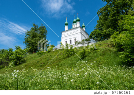 A snow-white church with green domes on the edge A snow-white church with green domes on the edge 67560161