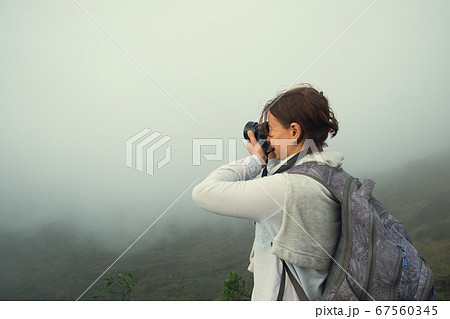 Caucasian woman making photo standing on the top 67560345