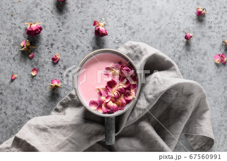 Rose moon milk in grey cup and rose petals on grey. Top view. 67560991