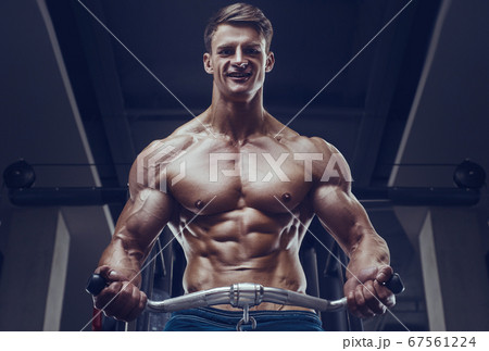 Bodybuilder strong man pumping up biceps muscles Bodybuilder strong man pumping up biceps muscles 67561224
