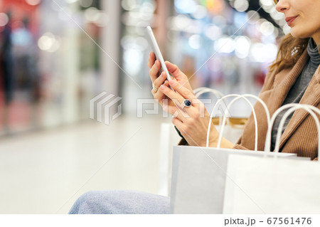 Hands of young elegant female shopper looking through adverts in the phone Hands of young elegant female shopper looking through adverts in the phone 67561476
