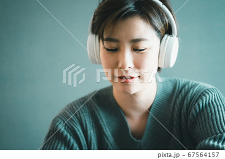 ワイヤレスヘッドホンで音楽を聴く30代女性 ワイヤレスヘッドホンで音楽を聴く30代女性 67564157