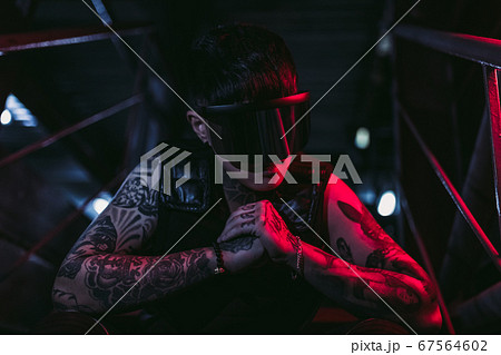 Cyberpunk style. Tattooed guy in one city. Cyber glasses. 67564602