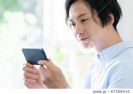 スマホで動画配信を見る男性 スマホで動画配信を見る男性 67566410