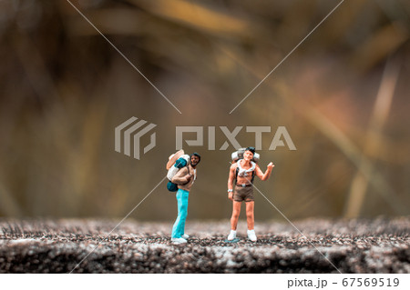 Miniature Backpacker standing on the concrete wall 67569519