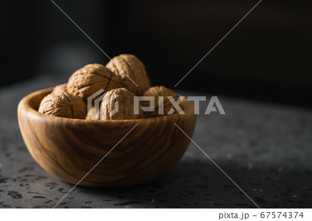 inshell walnuts in olive wood bowl on terrazzo countertop inshell walnuts in olive wood bowl on terrazzo countertop 67574374