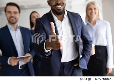 African boss holds out his hand for handshake welcoming customer 67576662
