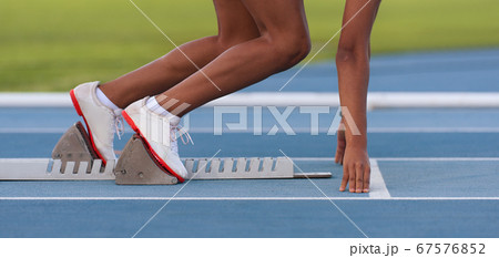 Woman in a starting block on an athletic field 67576852