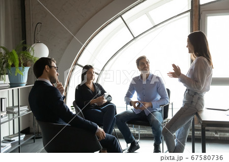 Motivated female leader head meeting with colleagues Motivated female leader head meeting with colleagues 67580736