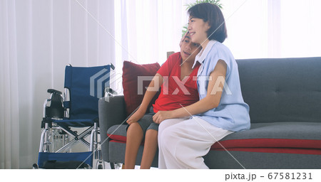 Happy family with mother and disabled son spending time together at home. Happy family with mother and disabled son spending time together at home. 67581231