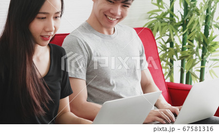 Happy Asian couple spending time together on sofa at home. Happy Asian couple spending time together on sofa at home. 67581316