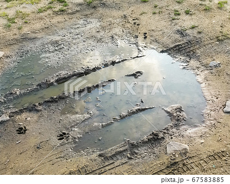 Puddle and mud with tire track texture. Muddy 67583885