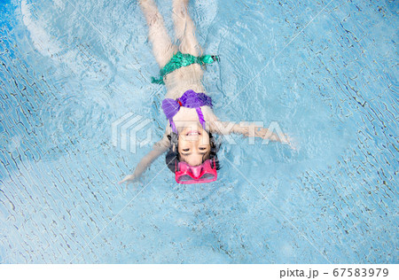asian kid big smile to playing swim in water pool 67583979