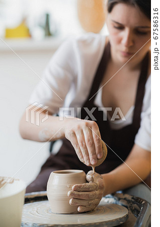 Master class on modeling of clay on a potter wheel In the pottery workshop Master class on modeling of clay on a potter wheel In the pottery workshop 67586316