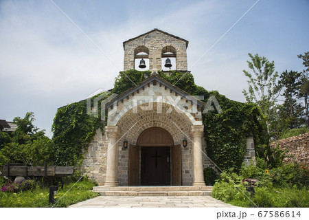 Medieval church building with two ringing bells on the top Medieval church building with two ringing bells on the top 67586614