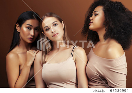 young pretty asian, caucasian, afro woman posing cheerful together on brown background, lifestyle diverse nationality people concept young pretty asian, caucasian, afro woman posing cheerful together on brown background, lifestyle diverse nationality people concept 67586994