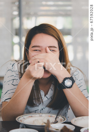 Woman eating food on dining table in restaurant 67592028