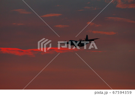 夕暮れの中を飛行するC-130ハーキュリーズ 67594359