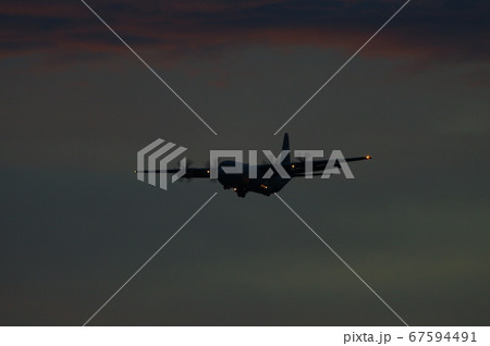 夕暮れの中を飛行するC-130ハーキュリーズ 67594491