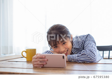 スマホで動画を見る若い女性 67595380