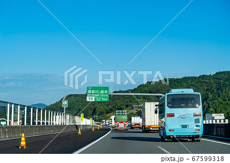 静岡県 新東名高速道路を走行中の観光バスとトラック もうすぐ森掛川インターチェンジの出口の写真素材