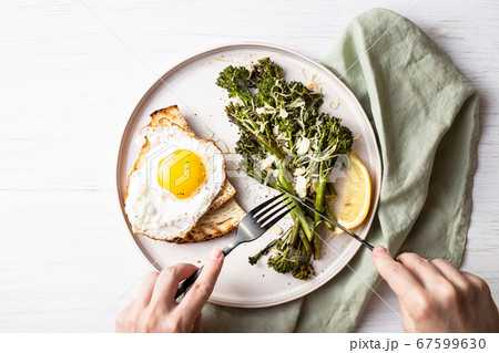Roasted broccolini with fried egg on the plate. 67599630