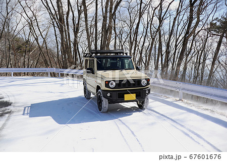四輪駆動の軽自動車で雪道を走る の写真素材