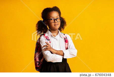 Serious Black School Girl Crossing Hands Posing Over Yellow Background Serious Black School Girl Crossing Hands Posing Over Yellow Background 67604348