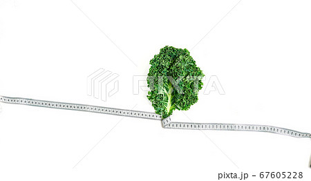 kale wrapped in measuring tape, concept diet, slimming, healthy eating top view, on white background kale wrapped in measuring tape, concept diet, slimming, healthy eating top view, on white background 67605228