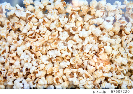 Popcorn background behind glass in a po pcorn Popcorn background behind glass in a po pcorn 67607220