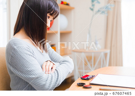 書類を確認する女性　様々な書類　腕組み　 67607465